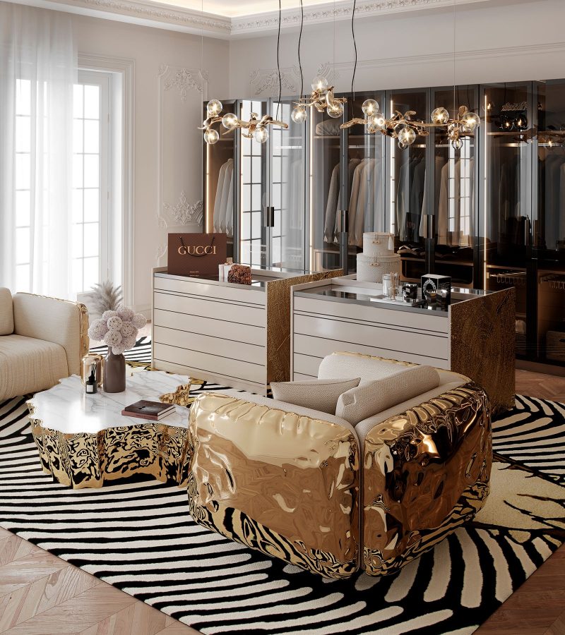 It is a dressing room containing wardrobes, a gold coffee table with a white top, and two beige and gold Imperfectio exceptional armchairs