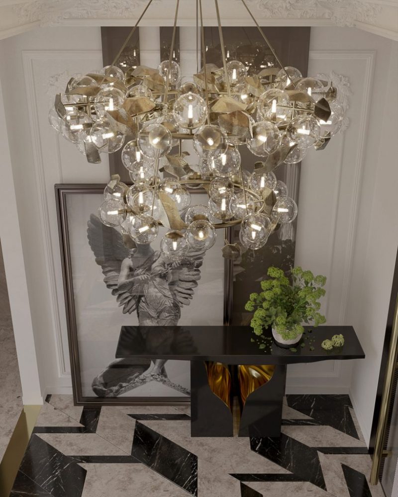 entryway with black console with gold interior and gold suspension lamp