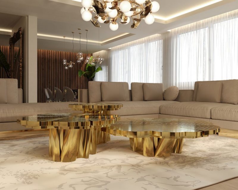 luxury living room with a l-shaped modern sofa enveloped by polished brass and  a center table made with polished brass and with three different tops in different levels