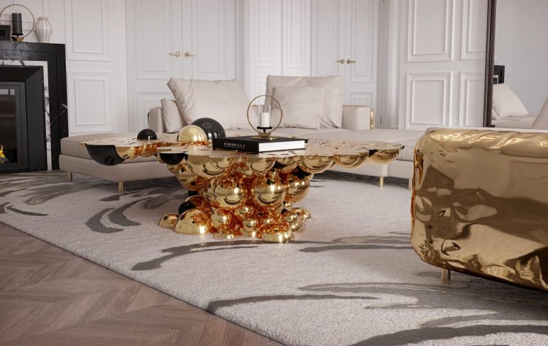 living room with l-shaped modern sofa enveloped by polished brass and  an oval center table built from aluminium spheres