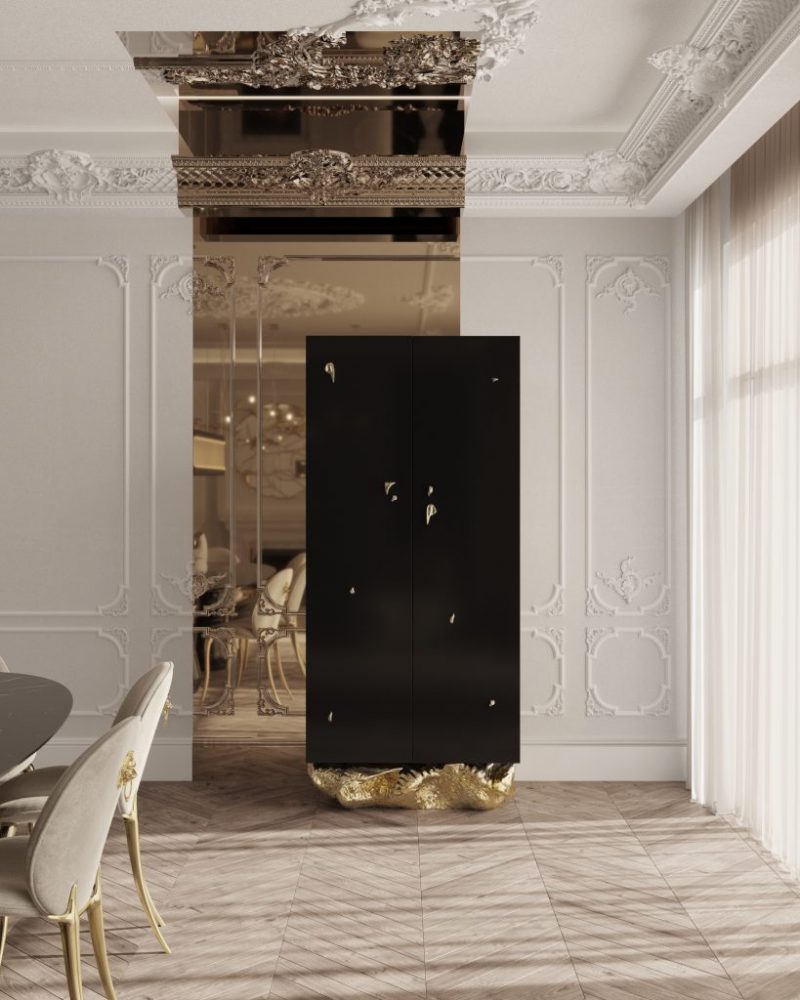 Angra Collection- contemporary dining room, white walls, black table, cream chairs with gold details, white curtains and a black cabinet with gold base