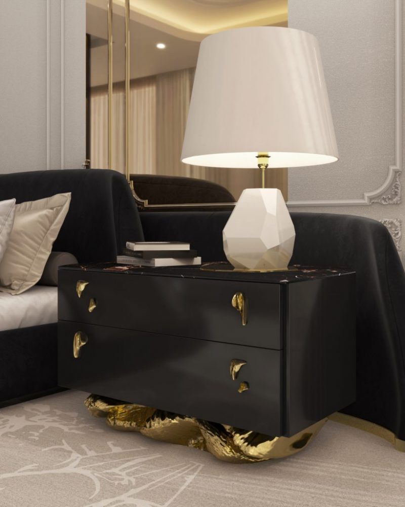 Angra Collection- bedroom with a black bed, cream and white rug and a luxurious black bedside table with gold base and handles with a white table lamp and books